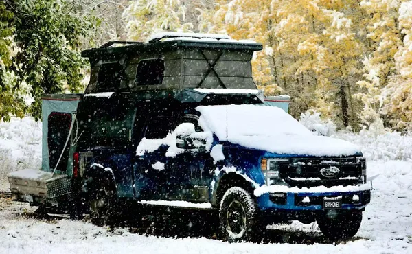 Ford Super Duty with a slide-in camper in fresh snow