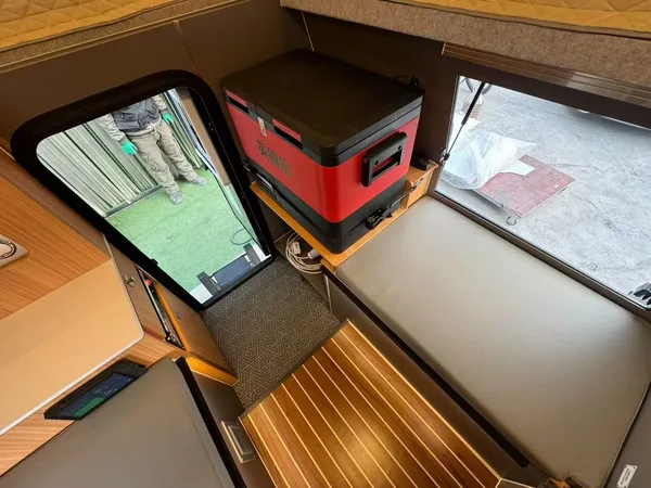 Warm-lit slide-in camper interior with wood table