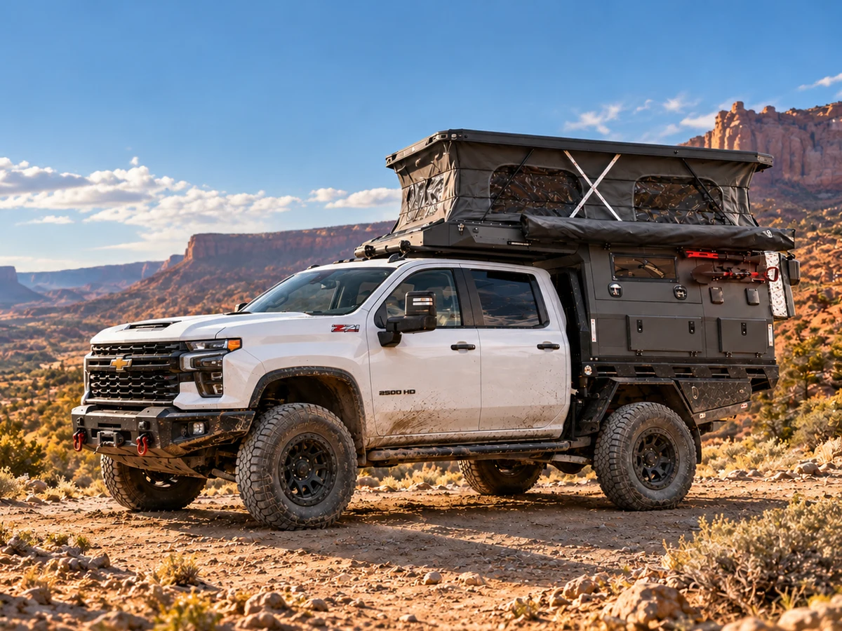 White Chevrolet Silverado 2500HD with a SUNHOMEE flatbed camper in desert canyon country
