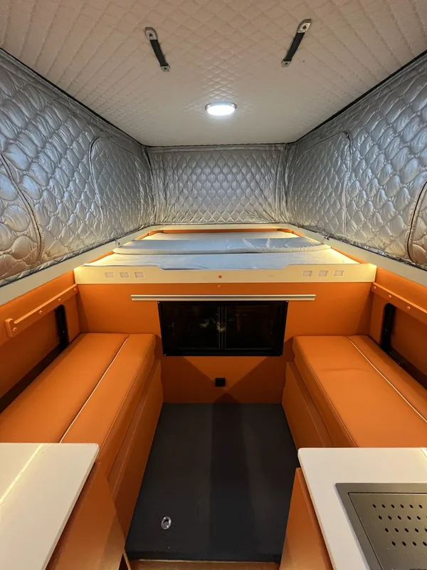Orange camper interior looking toward the cabover bed