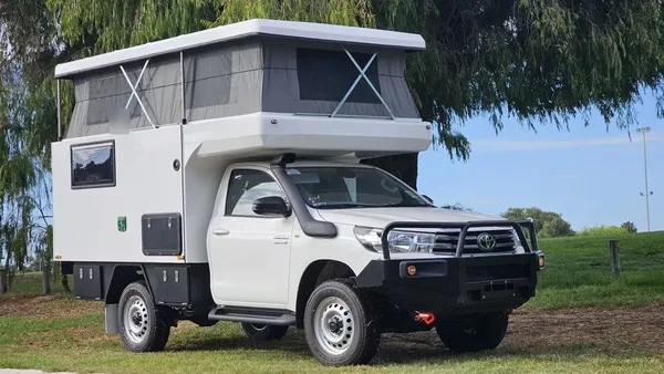 White SUNHOMEE flatbed camper with side door on a Toyota Hilux