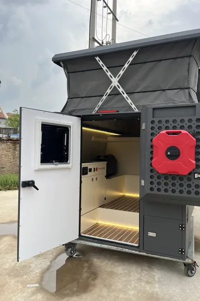 Rear of a SUNHOMEE flatbed camper with the door open and roof raised